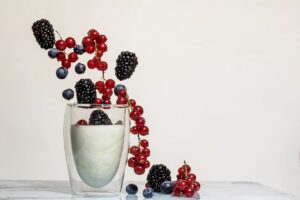 Glass of milk and different types of berries.